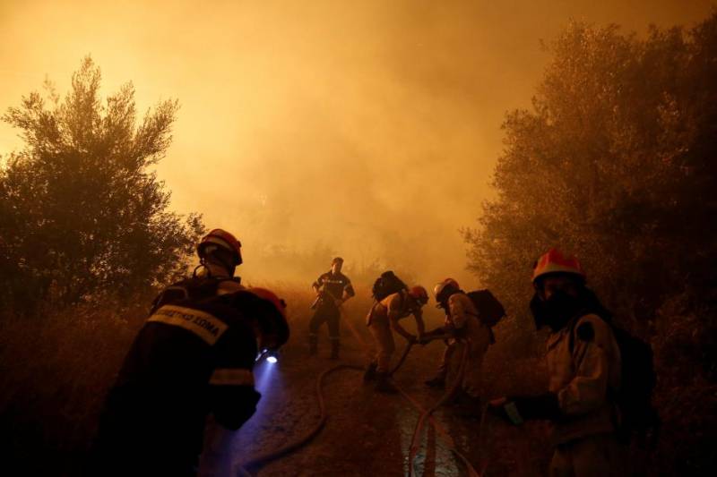 Firefighters battle spreading wildfire near Athens, homes damaged