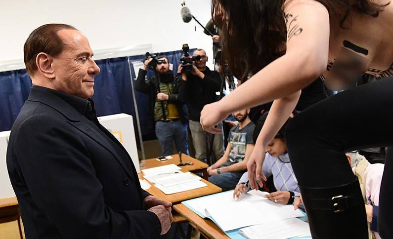 Video: Topless Femen protester confronts ex-PM Berlusconi at polling station